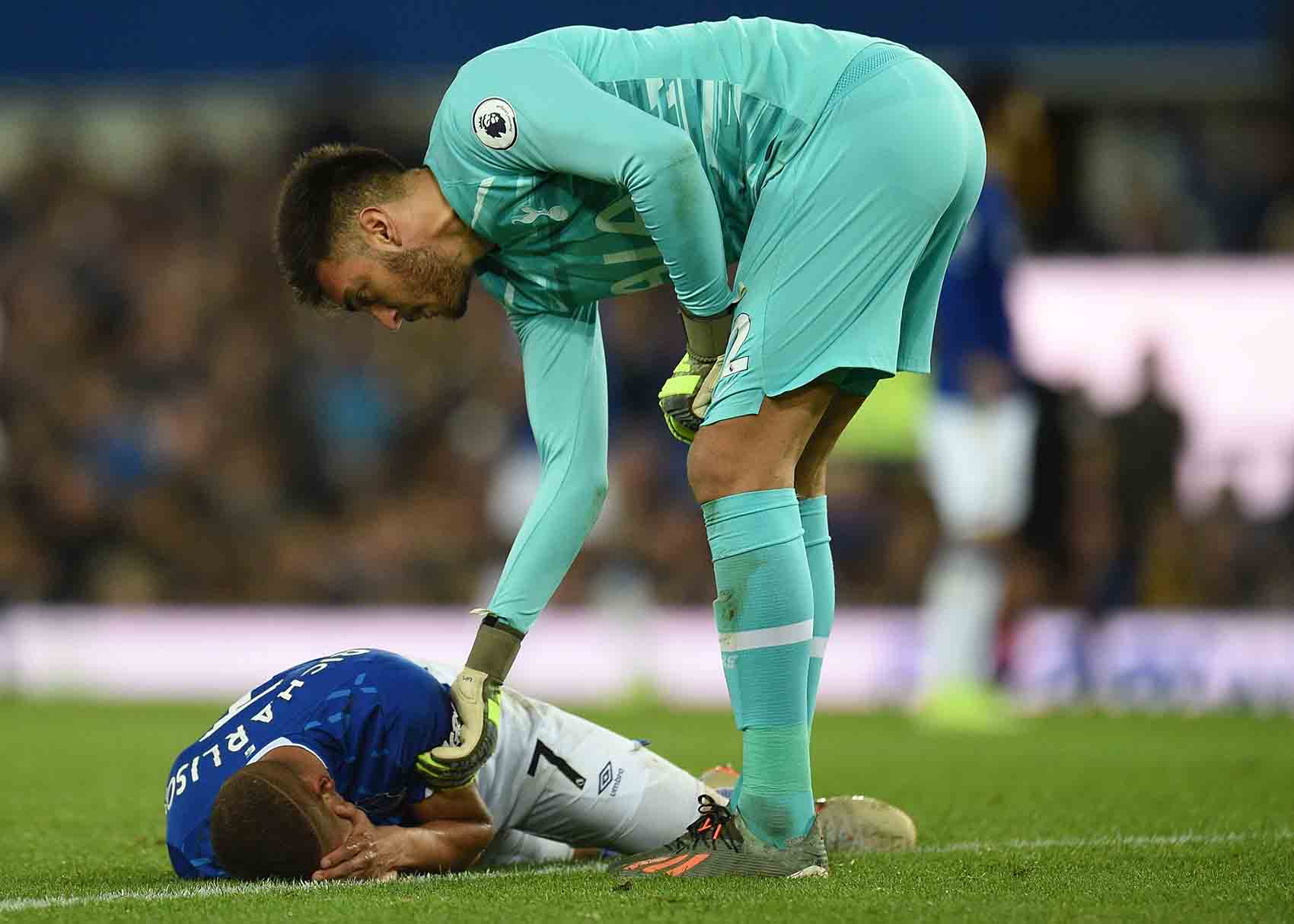 Richarlison is down holding his head following a collision with Tottenham keeper Gazzaniga